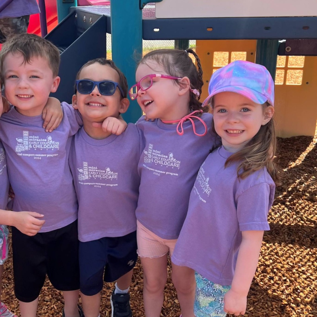 Students at Mini-Miracles in purple MMCC shirts posing for picture on playground