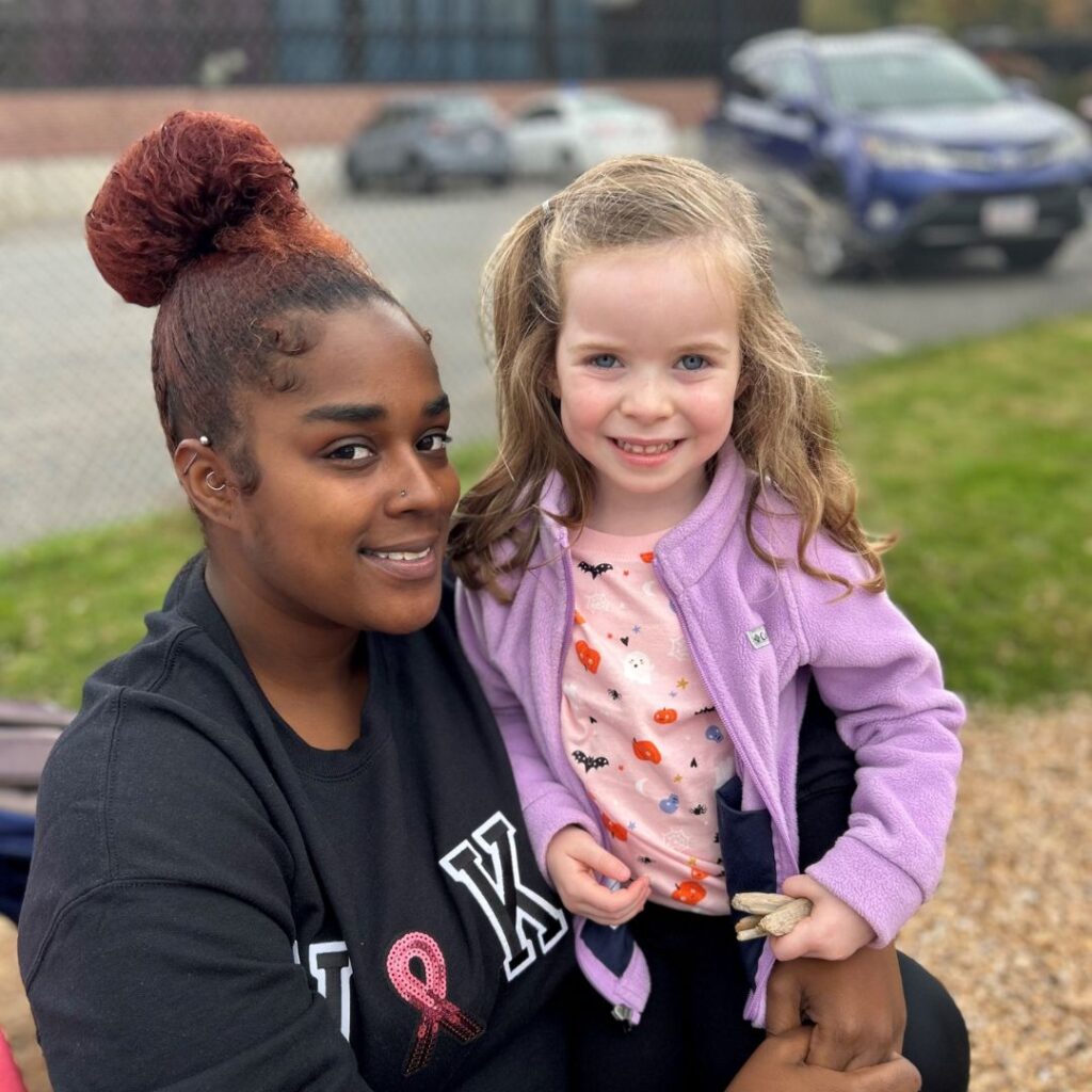 Student and teacher smiling together at Mini-Miracles Childcare playground